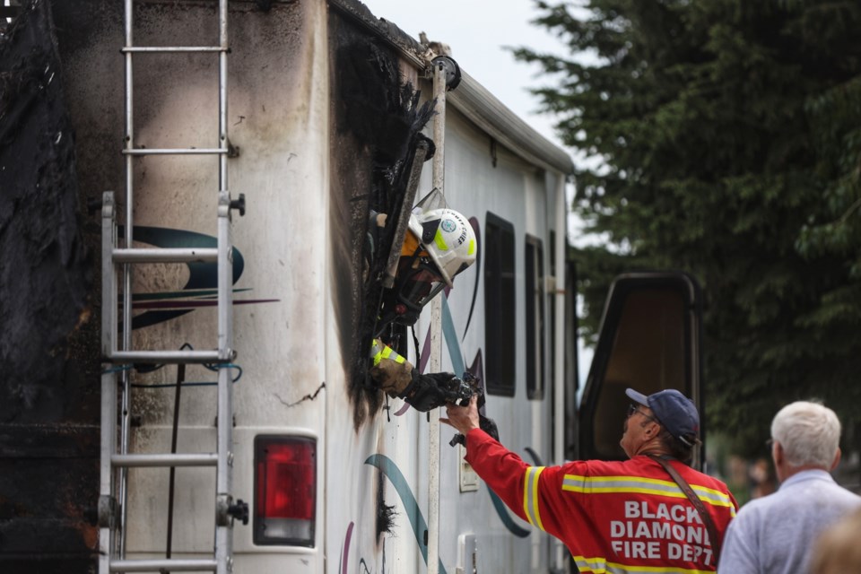 Firefighters tackle hot spots after responding to a call of a motorhome fully engulfed in flames in downtown Longview on May 26.