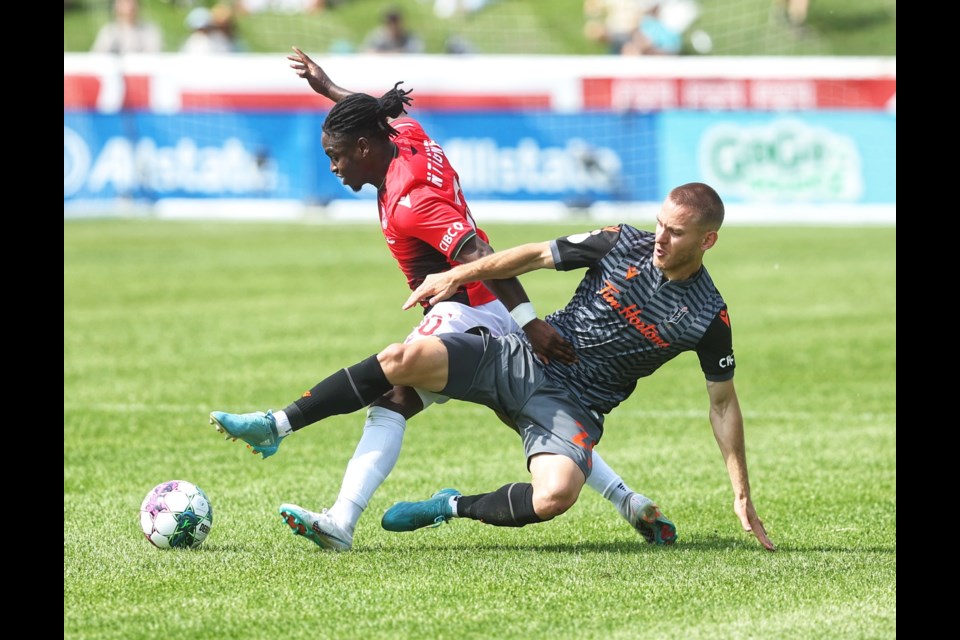 Cavalry FC's Goteh Ntignee and Forge FC's Rezart Rama clash at Spruce Meadows' ATCO Field on June 3. The teams played to a 1-1 draw.