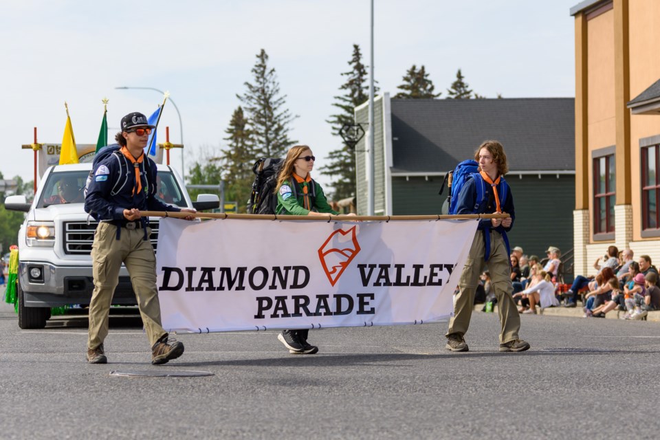 Members of the 1st Oilfields Turner Valley Scouts carry the parade banner during the Diamond Valley Parade on June 3. 