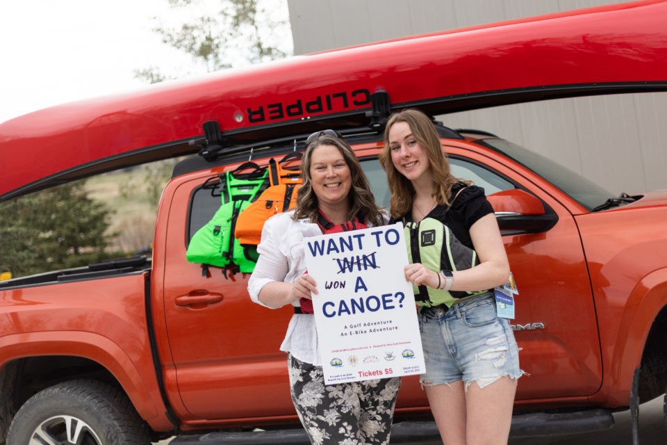 Gillian Gay and her daughter Emileigh pose with the canoe they won from the Beneath the Arch adventure raffle. Donated by Tom's Marine, the canoe package was valued at nearly $4,000.