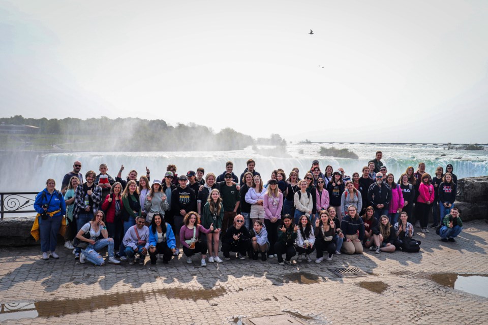 The Alberta High School of Fine Arts Vocal Ensemble, Concert Band and Jazz Band pose by the Niagara Falls while on a trip to  Music Fest Canada in May, where they racked up accolades. (Photo by Abby Keeler)