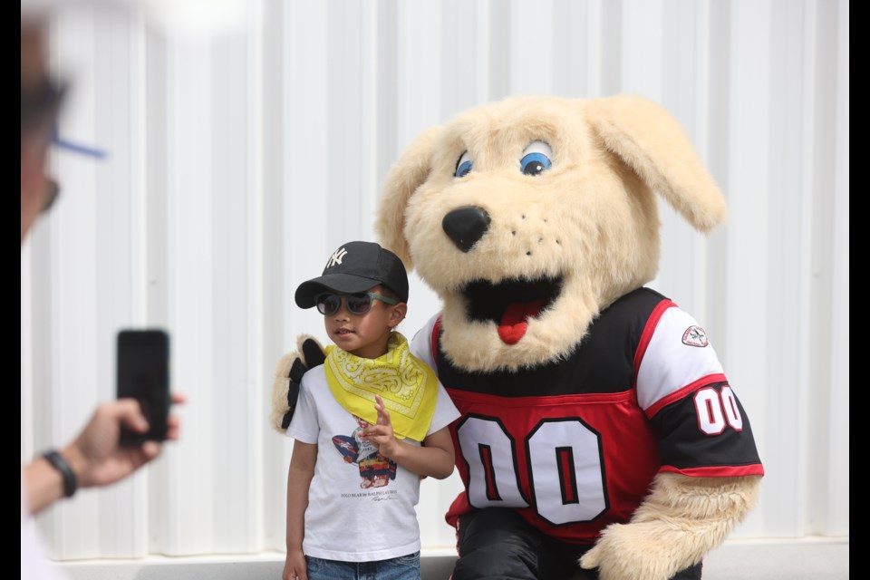 Daven Li gets his photo taken with Gordie the Calgary Bantam Football mascot during a Calgary Stampede 'Community Round-Up' event at the Cavalry FC Regional Field House on June 10.