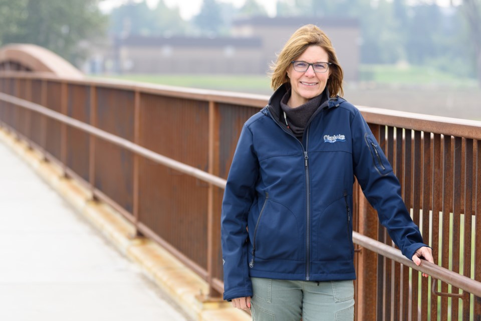 Okotoks Mayor Tanya Thorn stands on the Laurie Boyd bridge over the Sheep River on June 15. The Town's water treatment plant, in the background, was cut off during the 2013 flood, prompting a new access bridge to be built south of the plant.