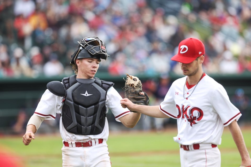 Okotoks Dawgs catcher Logan Grant shares a moment with pitcher Ryan McFarland at the end of an inning during the June 25 win over the Regina Red Sox at Seaman Stadium. Grant, a Dawgs Academy alumnus, is off to a torrid start in his first summer with the collegiate Dawgs. 