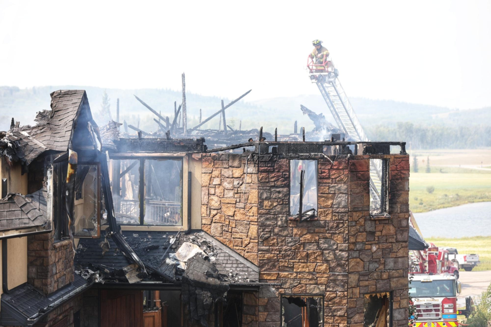 Firefighters work to tackle flames in a Millarville home on Aug. 4.