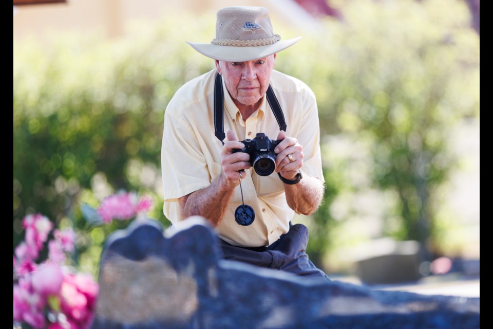 Ron Gilmore captures a digital image of a headstone at the Okotoks Cemetery on Aug. 11.