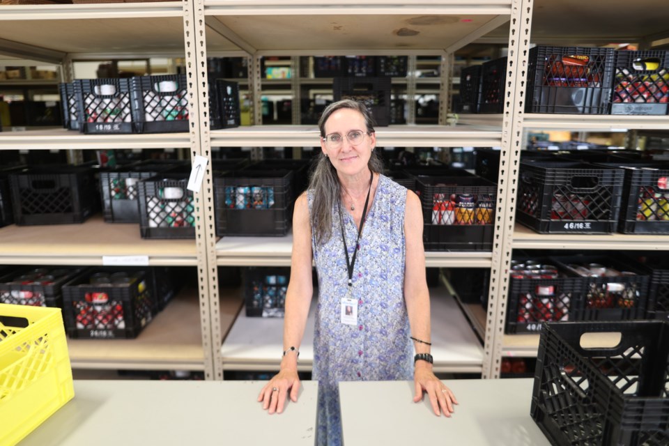 Director Pamela McLean stands in front of depleted shelves in the Okotoks Food Bank warehouse on Aug. 17.