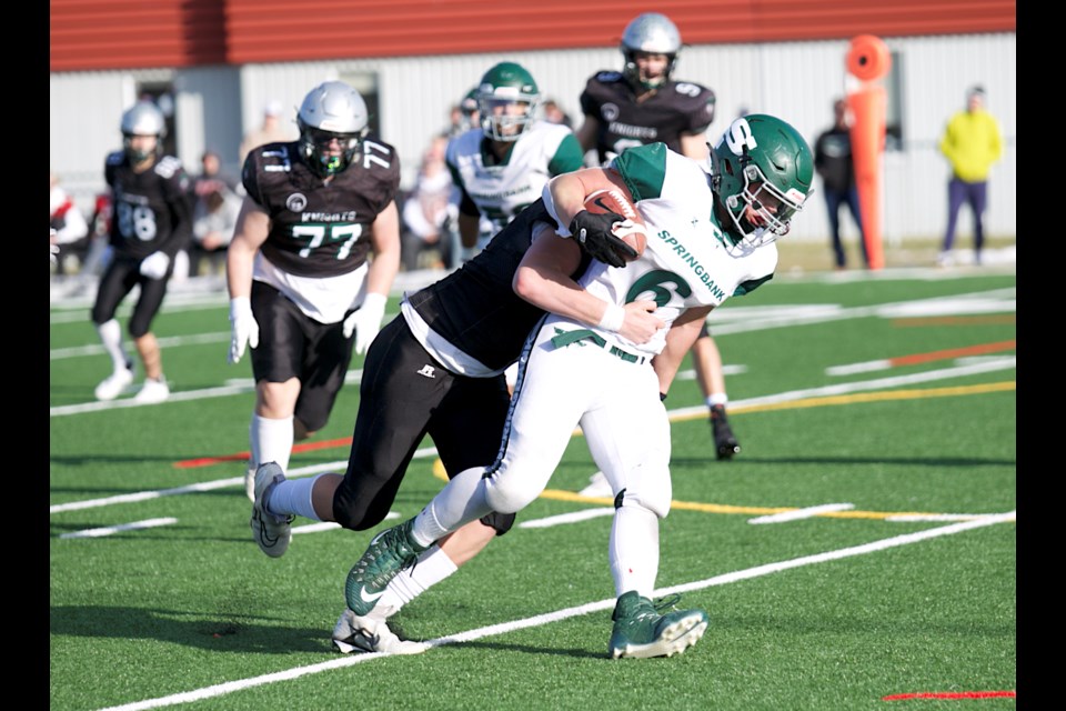 Springbank Phoenix fullback Matthew Schroeder tries to fend off a tackle from Holy Trinity Academy Knights defensive lineman Ben Haden during the Tier II high school football playoff match on Nov. 3 in Cochrane. The Knights won by a 41-0 score to eliminate the Phoenix from the provincial playoffs.