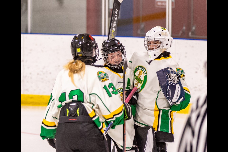 The Okotoks U15 B Oilers Green celebrate at the final buzzer after winning the gold medal game of the Okotoks Female Hockey Classic by a 5-0 score over the GHC Ignite on Nov. 12 at the Murray Arena. From left: Avery Herbert, Hannah Miller and goalie Kahli Giesbrecht. 