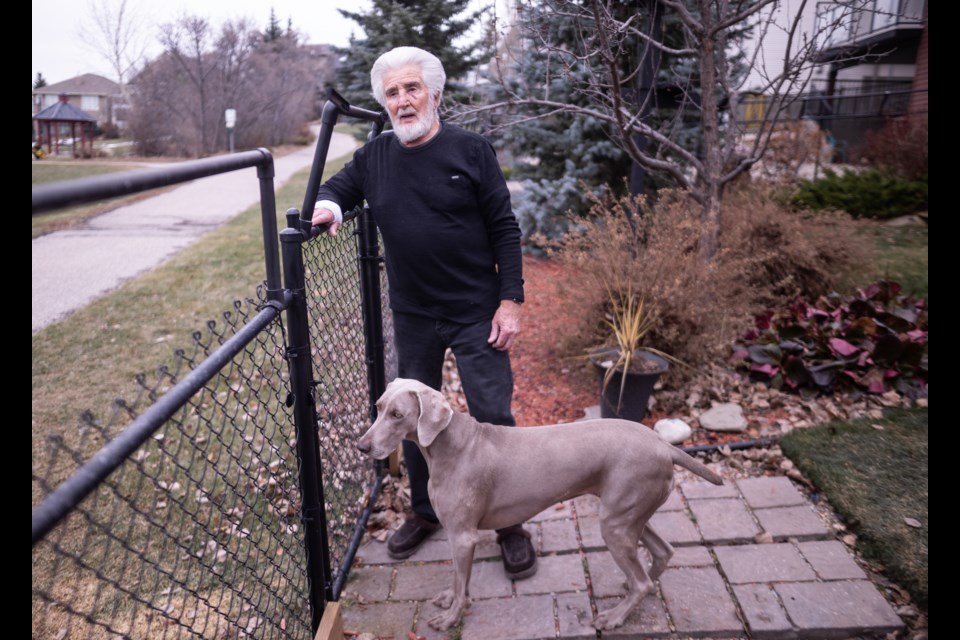Tony Nolan and his dog Kit in their back yard on Nov. 15. Nolan suffered various injuries to his face, hands, body, and legs after fending off a doe that attacked Kit in the yard the day prior.