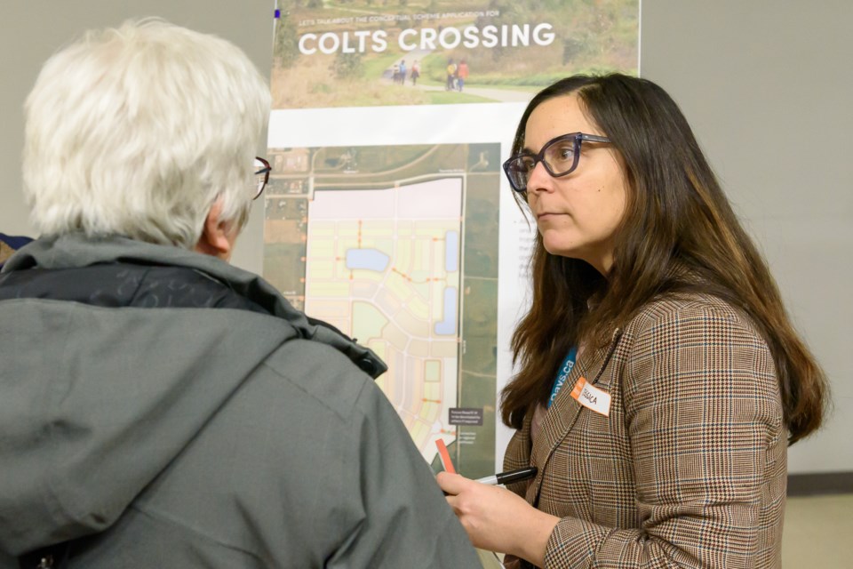  Jessica Karpat, principal - planning with QuantumPlace Consulting, speaks with attendees at an open house for Colts Crossing at the Flare n' Derrick Community Centre on Nov. 28.