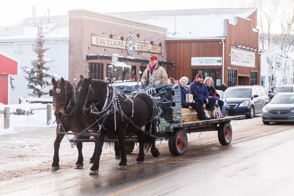A horse-drawn wagon takes visitors for a ride through Turner Valley during Eau Claire Distillery's Winter Whisky Wonderland on Dec. 10.