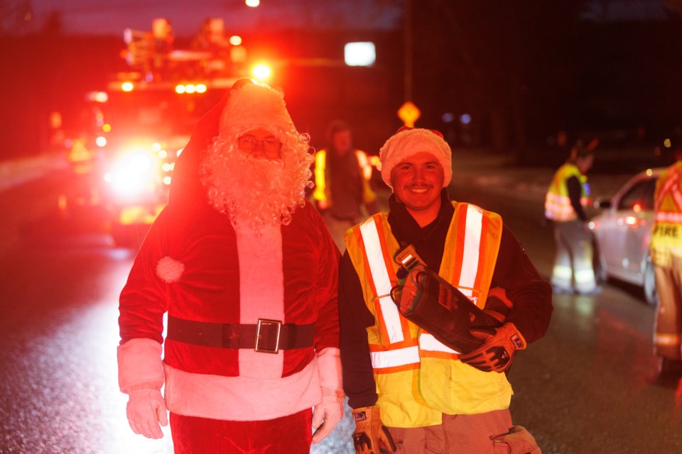 Firefighter Nicholas Warkman poses with Santa Claus during the Diamond Valley Candy Cane Check Stop on Dec. 15.