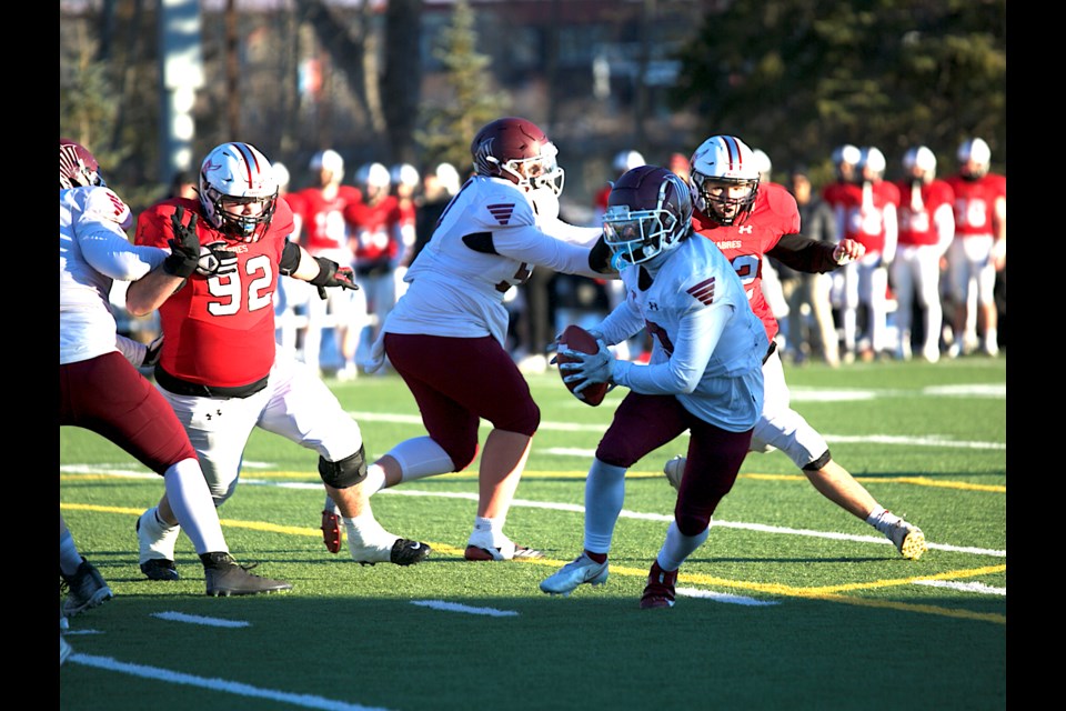 Foothills Falcons quarterback Emerson Liepert escapes the rush of the Salisbury Sabres during the Football Alberta Tier I Provincial Final on Nov. 25 at Red Deer’s Great Chief Park. The Sabres won the game 34-27 in overtime. (Remy Greer/Western Wheel)