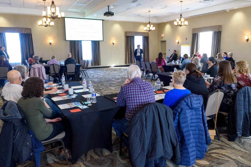 Attendees listen as a government official provides an overview of the UCP government's plan to refocus health care during an engagement session at the Best Western Okotoks Inn & Suites on Feb. 1.