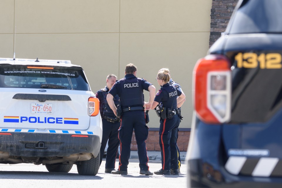 Police officers from the Okotoks RCMP and Calgary Police Service investigate at a parking lot in the Westmount Centre business park on Southridge Drive in Okotoks after making two arrests related to stolen vehicles on April 15. 