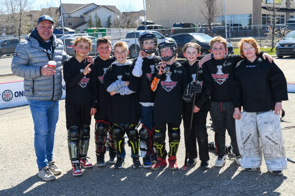 Kelly Hrudey, left, stands for a photo with one of the teams that played in the Okotoks Nissan Hockey Day in Canada street hockey tournament at the dealership on April 20.