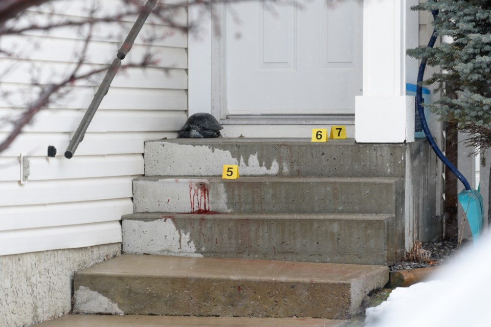 What appear to be blood stains on the stairs of a home are marked as evidence after a shooting on Sheep River Court Okotoks on May 1.