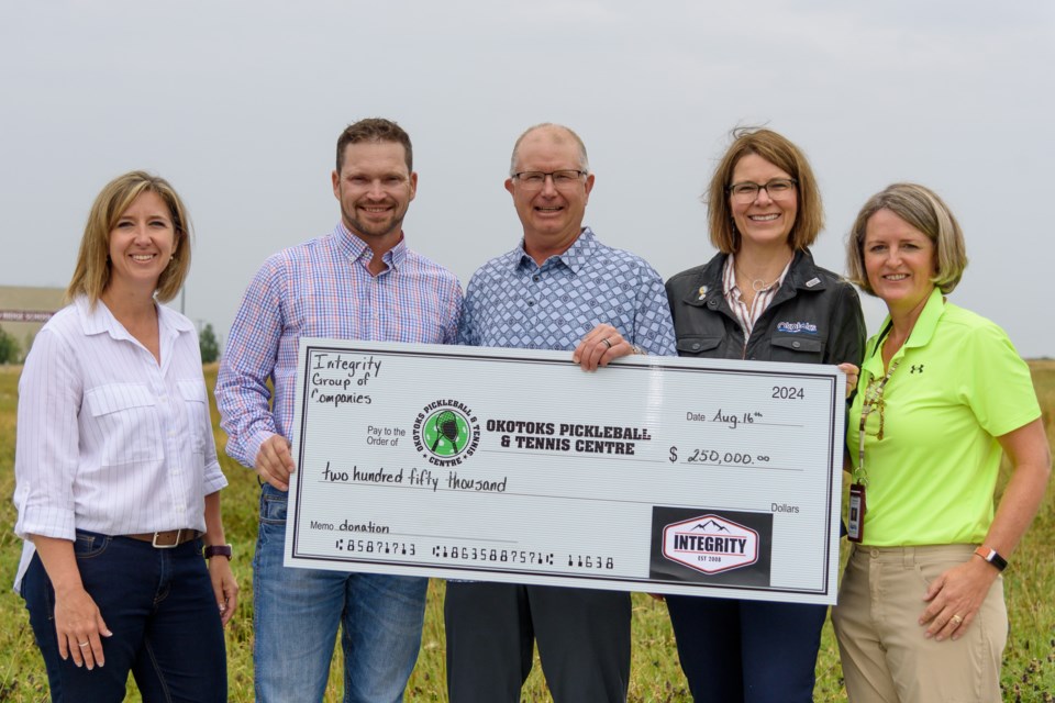 From left to right: Integrity Group of Companies co-owner Shanna Groeneveld, founder Jerry Myer, OKPTC president Ryan Sawatzky, Okotoks Mayor Tanya Thorn and Okotoks Parks and Recreation Director Christa Michailuk attend an announcement for the Okotoks Pickleball & Tennis Centre in Okotoks on Aug. 16. Integrity Group of Companies presented a $250,000 donation to the pickleball centre and Integrity Post Structures will build the facility.
