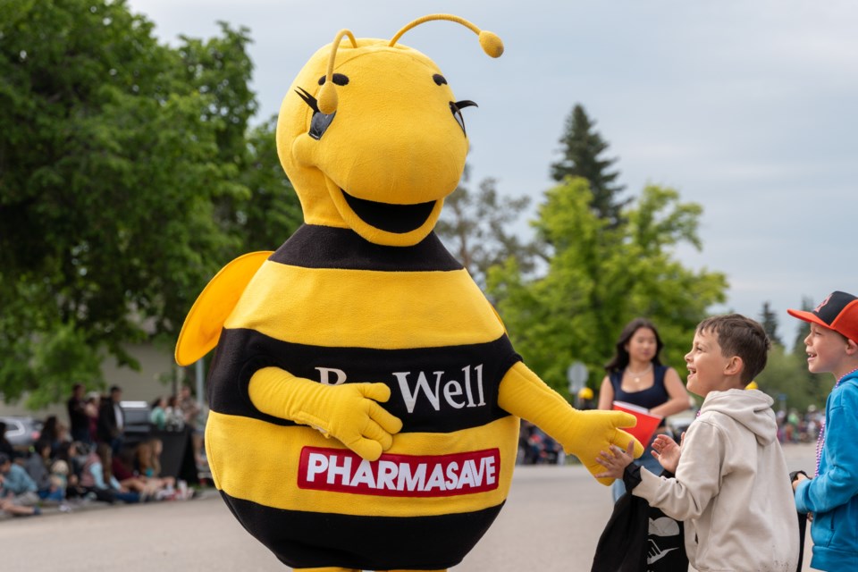 The Pharmasave Bee hi-fives with kids at the Diamond Valley Parade on June 7.