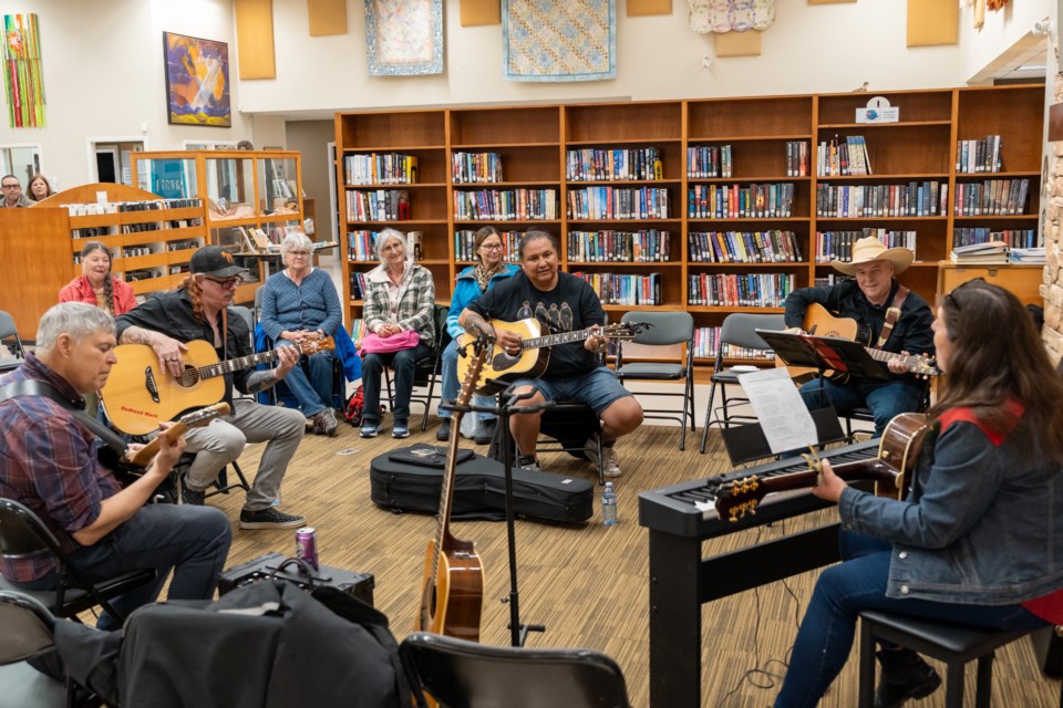 Walter White Bear, middle, and musicians play at a jam session at the Sheep River Library in Diamond Valley on June 21.
