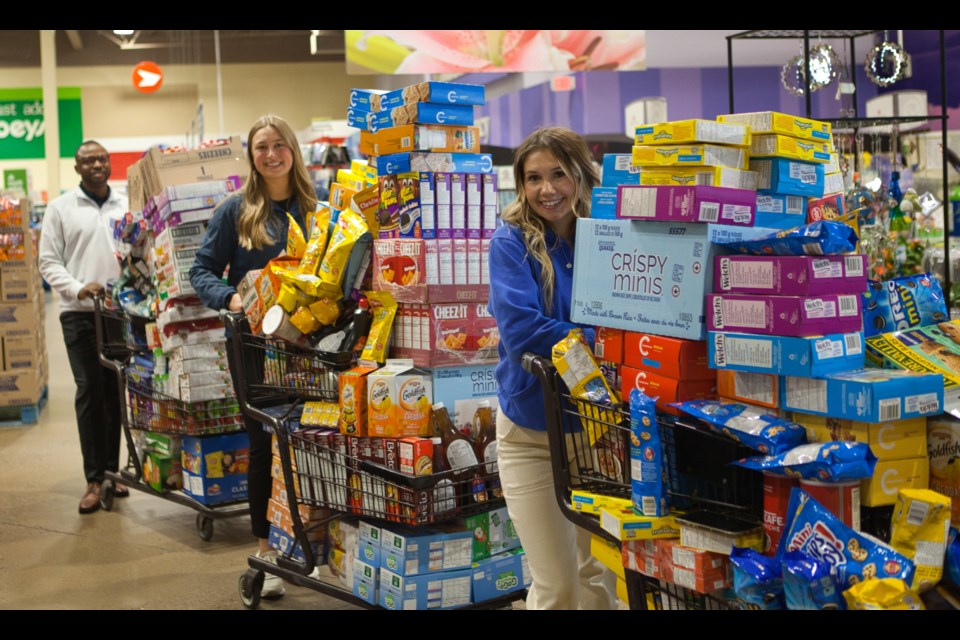 With no more room in their carts, Grace Neufeld, Janai Froese and Thabiso Hlatshwayo line up at the checkout.
