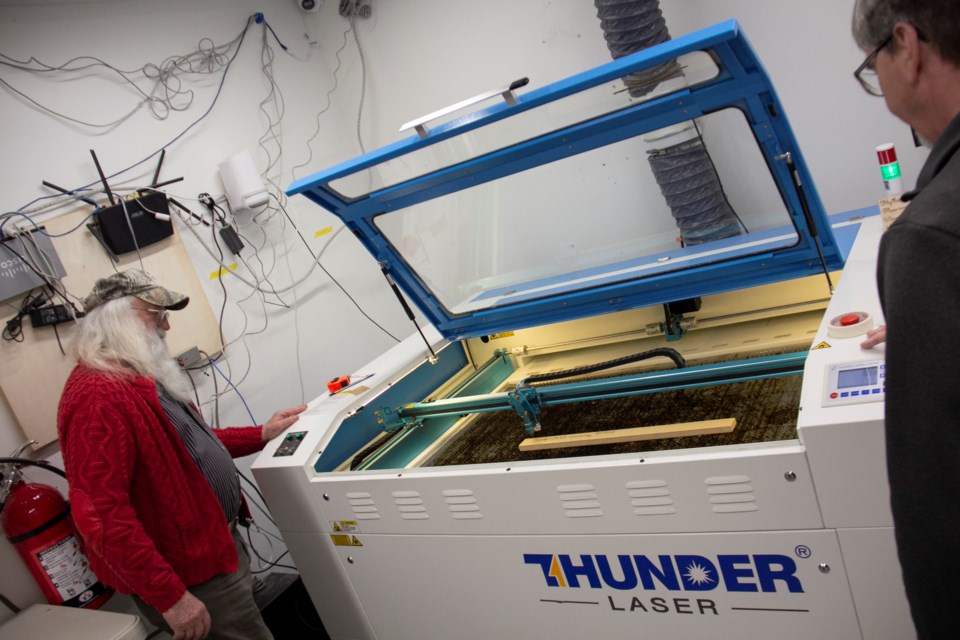 Larry Kapustka and Brian Ouhl demonstrate the laser cutter.