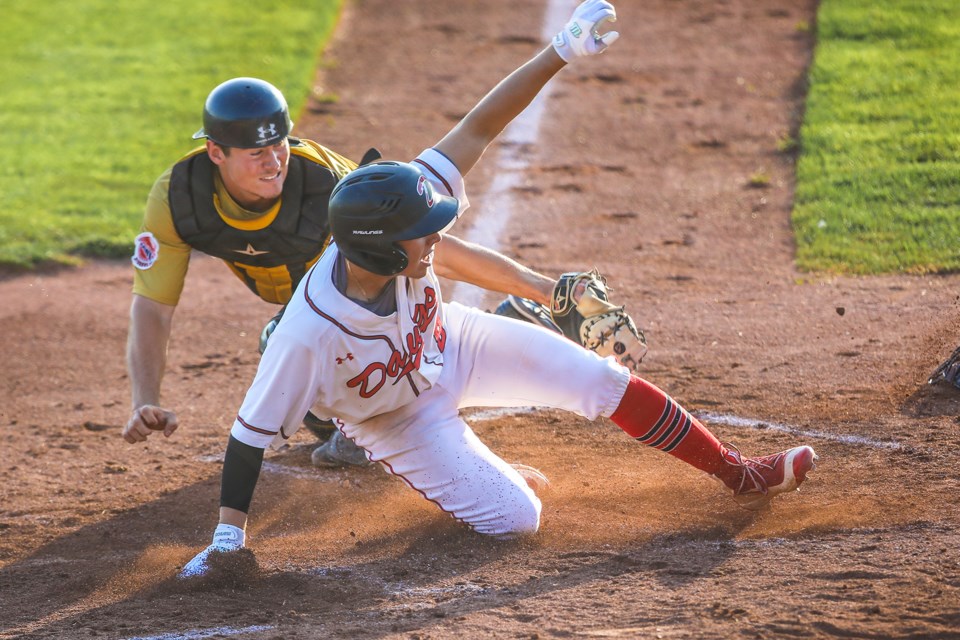Okotoks Dawg Ricardo Sanchez slides home to score the first run in the the playoff series against the Edmonton Prospects at Seaman Stadium on Aug. 8. (BRENT CALVER/Western Wheel)