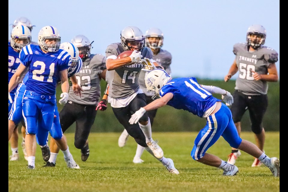 Holy Trinity Academy Knight Noah Gutek evades a Catholic Central Cougar tackler during the 45-20 win on Aug. 29 in Okotoks. (BRENT CALVER/Western Wheel)