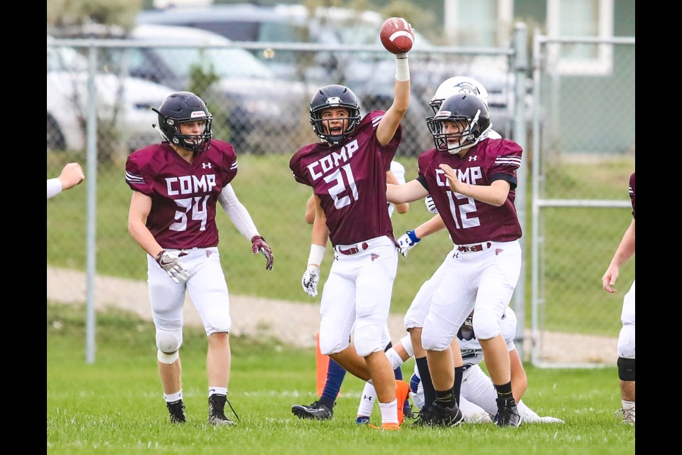 Foothills Falcons defensive back Jamison Strilchuk (21) holds up the ball after a key interception against the Strathmore Spartans on Sept. 6. He's flanked by Falcons teammates Sam Simard (34) and Abraham Wallace (12). Foothills won the game by a 22-8 score. (BRENT CALVER/Western Wheel)