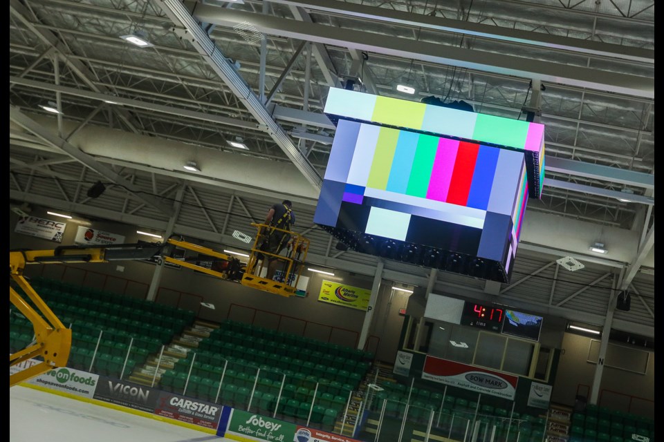 Pason Centennial Arena's new centre ice screen gets hoisted into place on Sept. 5. (BRENT CALVER/Western Wheel)
