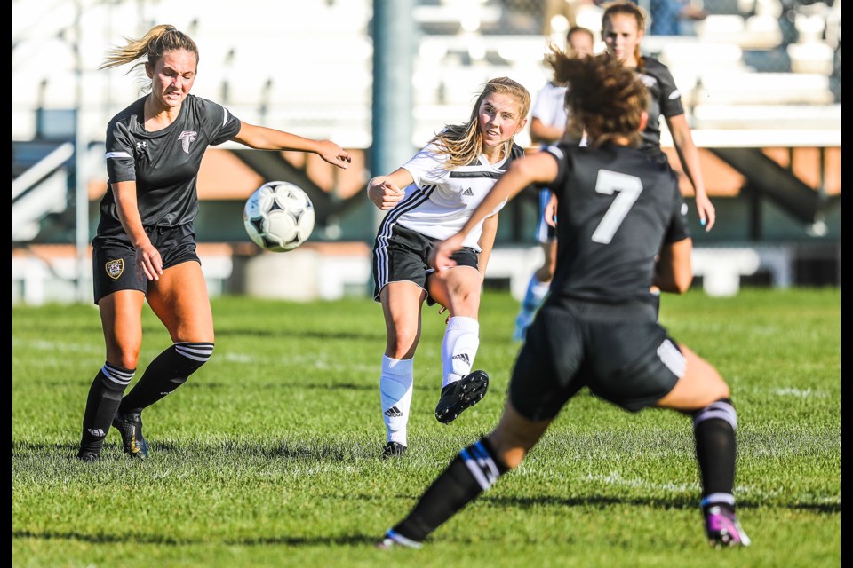 HTA Knights striker Brielle Masse curls in a left-footed strike for the the team's fourth goal in the 5-1 win over Foothills Composite on Sept. 19. (BRENT CALVER/Western Wheel)