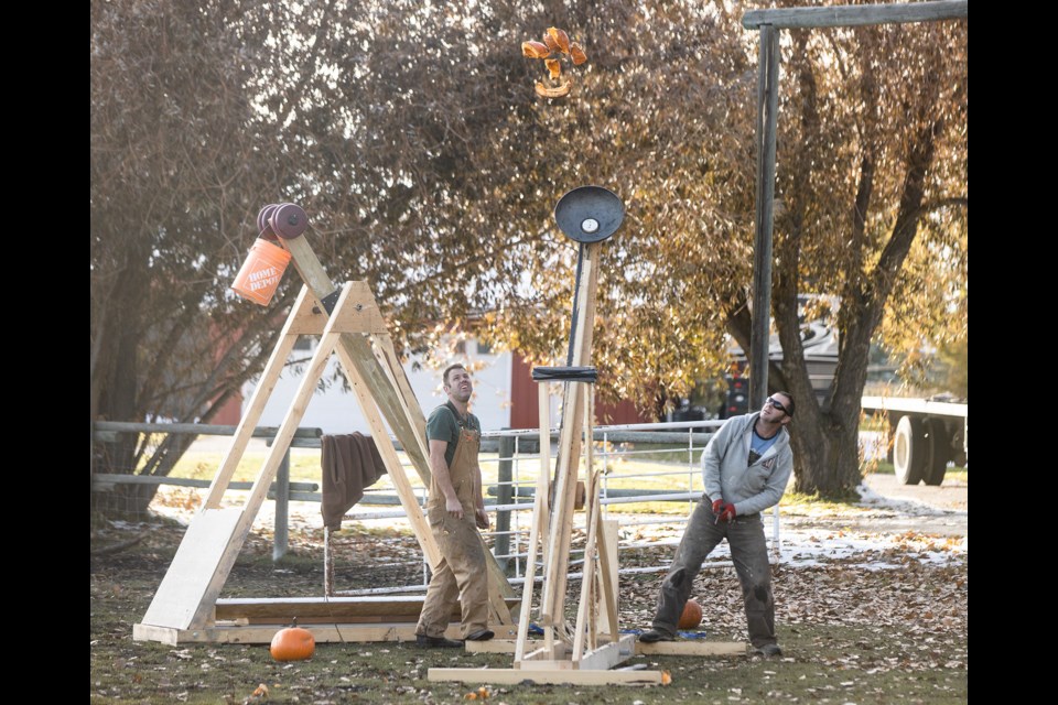 Guy Giroux, left, and his brother Paul Giroux pose on Oct. 12. with the trebuchet and catapult that they built for the Pumpkin Chunkin event organized Guy's wife Amy. The event will take place at the Country Living Centre on Oct. 19 from 11 a.m. to 2 p.m. (BRENT CALVER/Western Wheel)