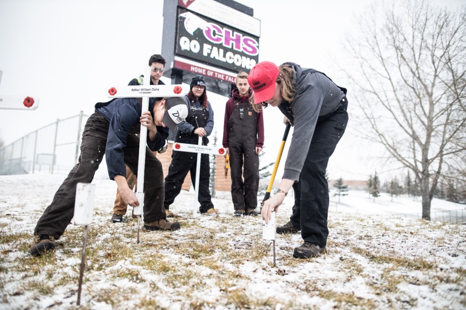 From left, Foothills Comp fabrication students Joshua Geerlinks, Chase Palmer, Ayana Patterson, Emerson Holst, and Avery Staiman places crosses on Southridge Drive on Nov. 5 to commemorate fallen soldiers from Okotoks. (BRENT CALVER/Western Wheel)