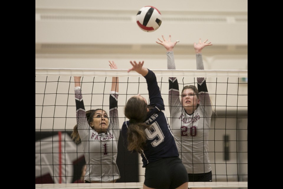Foothills Falcons Mayla Melnechenko (1) and  Emma Moore (20) attempt to block Strathcona-Tweedsmuir Spartans Sydney Evans' spike at the Foothills Athletic Council semifinal volleyball match on Nov. 4 at the Comp. (Bruce Campbell/Western Wheel)