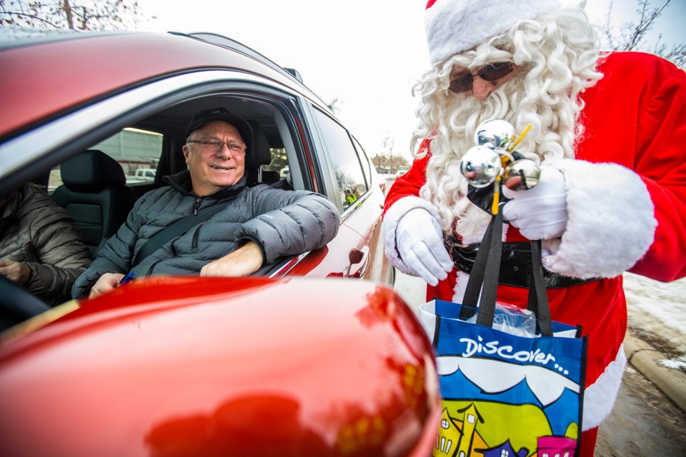 Santa hands out swag for drivers who stop to donate to the the 2019 Charity Checkstop on Dec. 18. The event, held on Milligan Drive each year, raises funds and food donations for both the Okotoks Food Bank Association and the Rowan House Emergency Shelter (BRENT CALVER/Western Wheel)