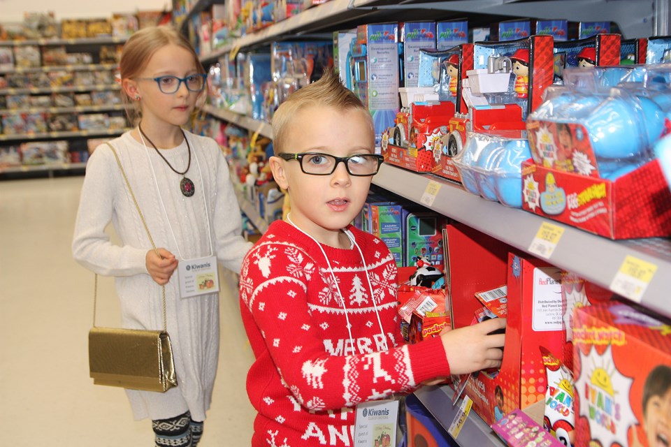 Lyla and Liam Johnston look for gifts for their siblings at the  Kiwanis Kids’ Christmas Toy Project on Dec. 15 at Walmart. (Bruce Campbell/Western Wheel)