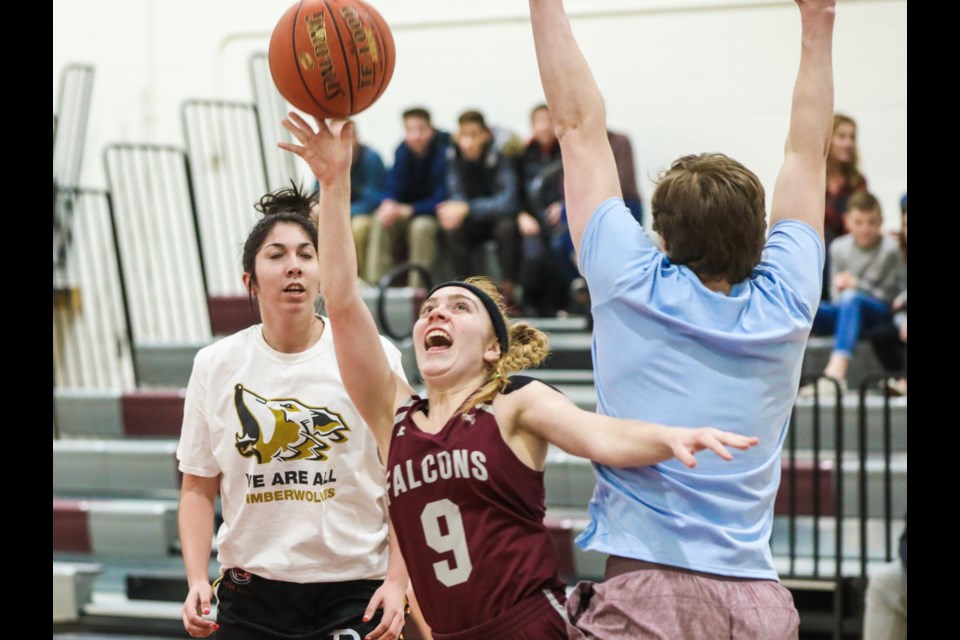 Falcon Makayla Porteous tries to shoot over alumnus Logan Richards. Alum Cevanna Carlson is in the background. The charity game on Dec. 18 at the Comp, raised $400 for multiple sclerosis research. (BRENT CALVER/Western Wheel)