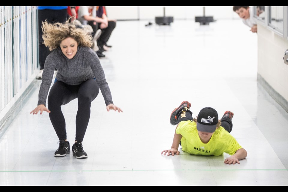 Teacher Cheryl Hutton (left) and Kenton Barnes try out a Canadian Forces physical qualifier test during a Wellness Conference at Okotoks Junior High School on Jan. 31. (Brent Calver/Western Wheel)