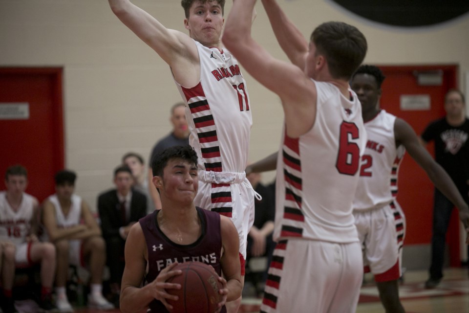 Foothills Falcon Tyson Camel is surrounded by Western Canada Redhawks in the final of the 2020 Redhawks Invitationat tournament final on Feb. 8. (Bruce Campbell/Western Wheel).