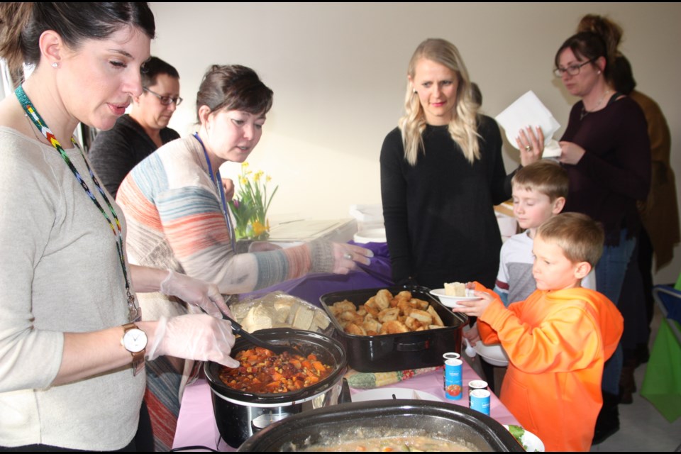 Charity Tegler, the Foothills division First Nations, Metis, Inuit success coach, serves bannock and soup to students and parents at the opening of the Gathering Space on March 11. (Bruce Campbell/Western Wheel)