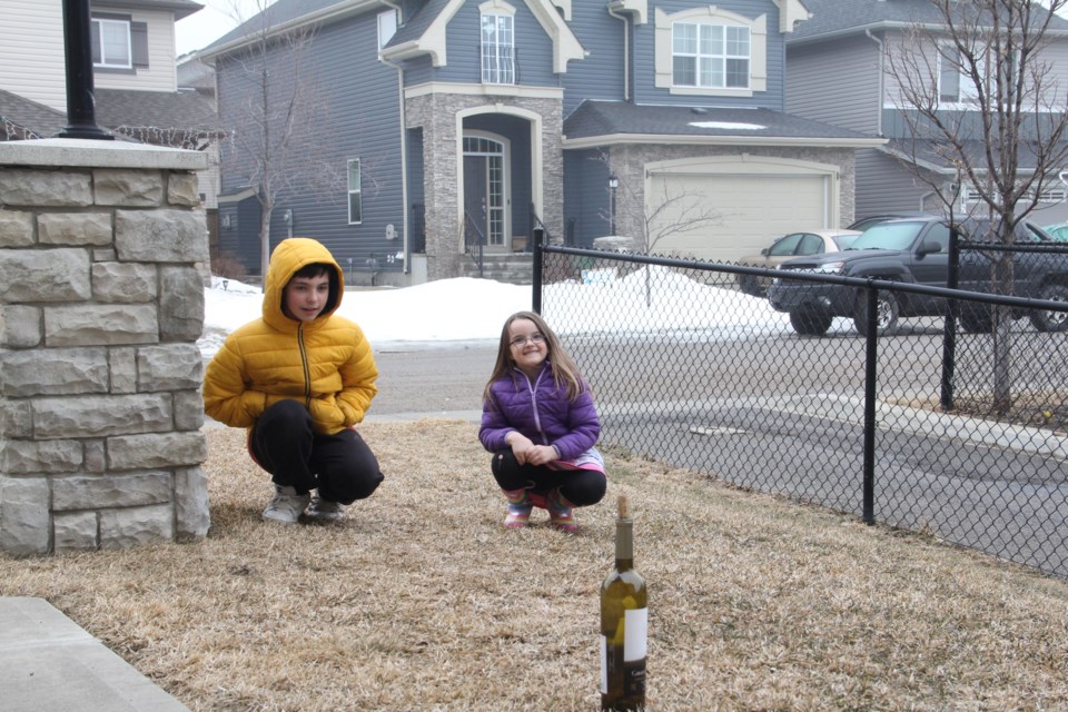 Christian and Hannah wait for the cork on their bottle to launch into the air on March 30.