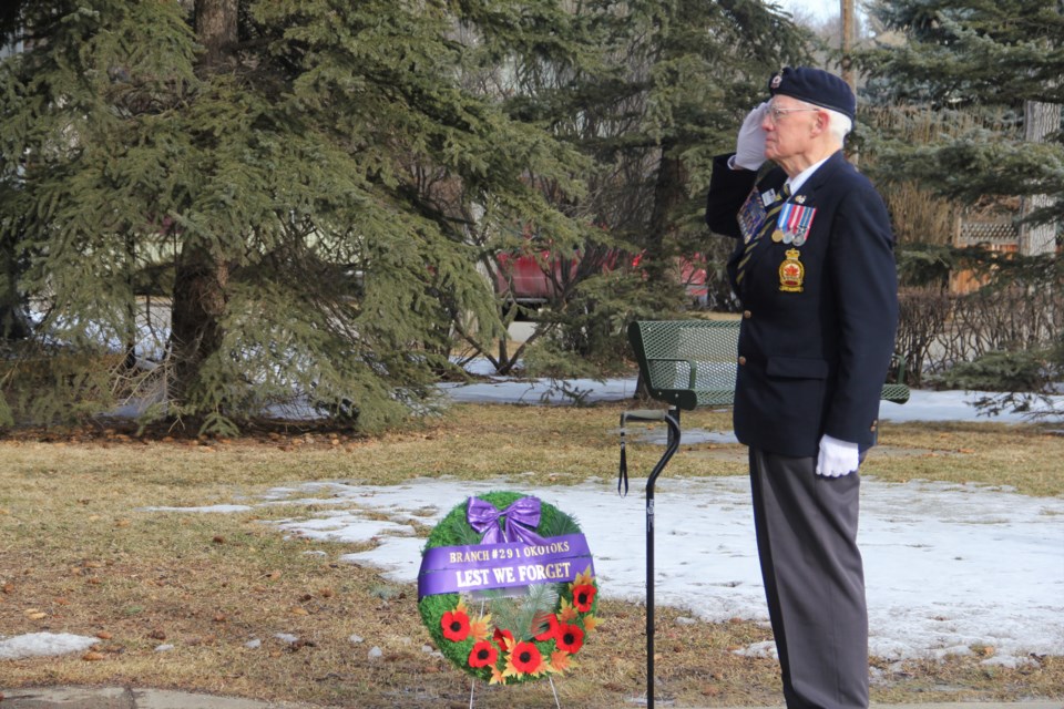 Malcolm Hughes, chairman of the Royal Canadian Legion Branch #291 Okotoks, salutes the Canadian flag during the playing of the national anthem at a Birth of the Nation Day ceremony to commemorate the Battle of Vimy Ridge on April 9. (Krista Conrad/Western Wheel)