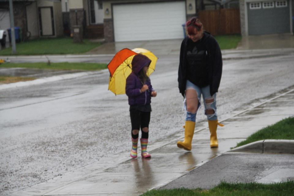 Brooke and Hannah stroll down the rainy sidewalk on May 21.