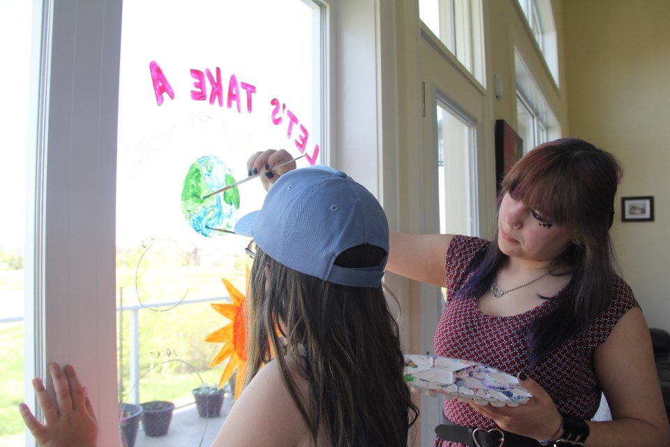 Brooke and Hannah paint the Earth on our playroom window on May 29.