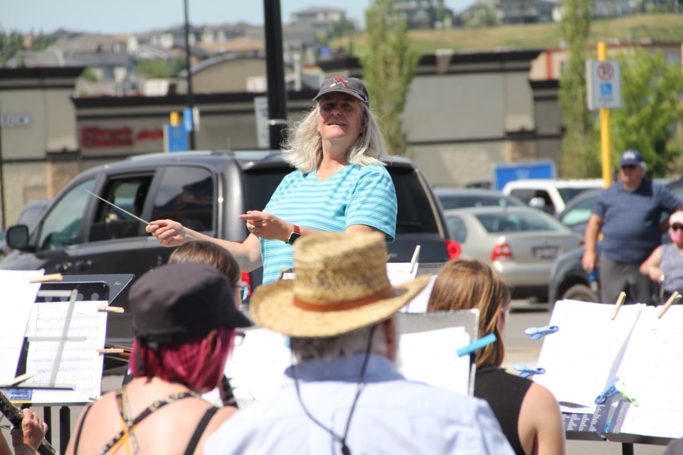 Kathie Van Lare conducts the Foothills Music Society and Sherwood Like to Play concert bands during the Party in the Parking Lot outdoor concert on July 11. (Krista Conrad/Western Wheel)