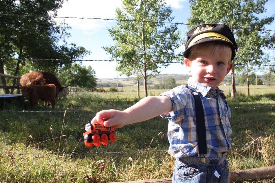 Sam Broadfield, 2, shows off his train at Hartell Homestead during Alberta Open Farm Days on Aug. 15. (Krista Conrad/Western Wheel)