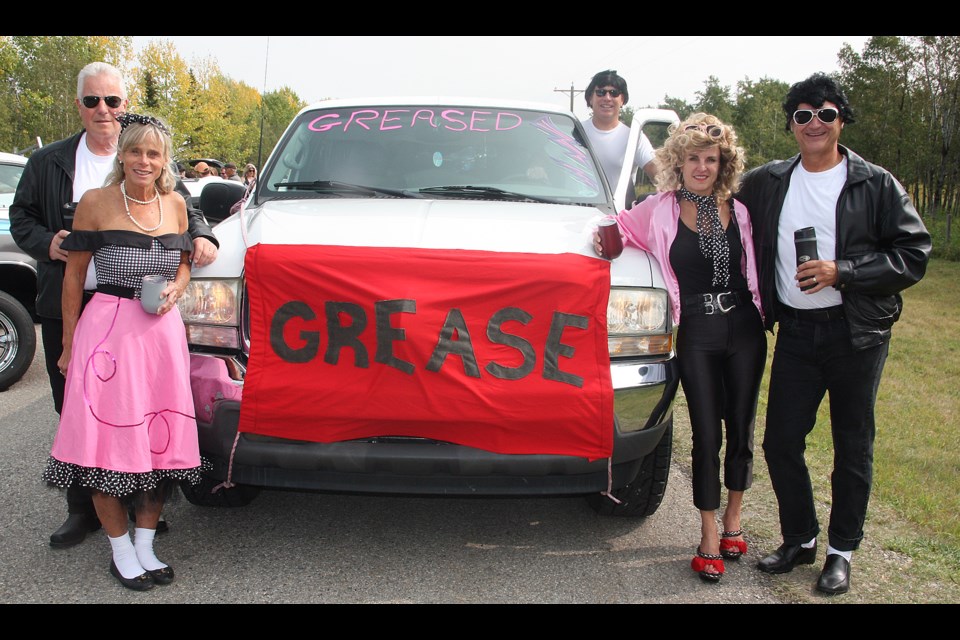 A group decked out in 1950s gear, gets set to head out in their Grease vehicle, which is wearing a mask for the Rally 4 Hospice on Sept. 12. From left are Gary Moore, Jan Moore, driver Jim Kyfiuk, Christo Rabie and Dr. Ana Maria Oelschig. (Bruce Campbell, Western Wheel)