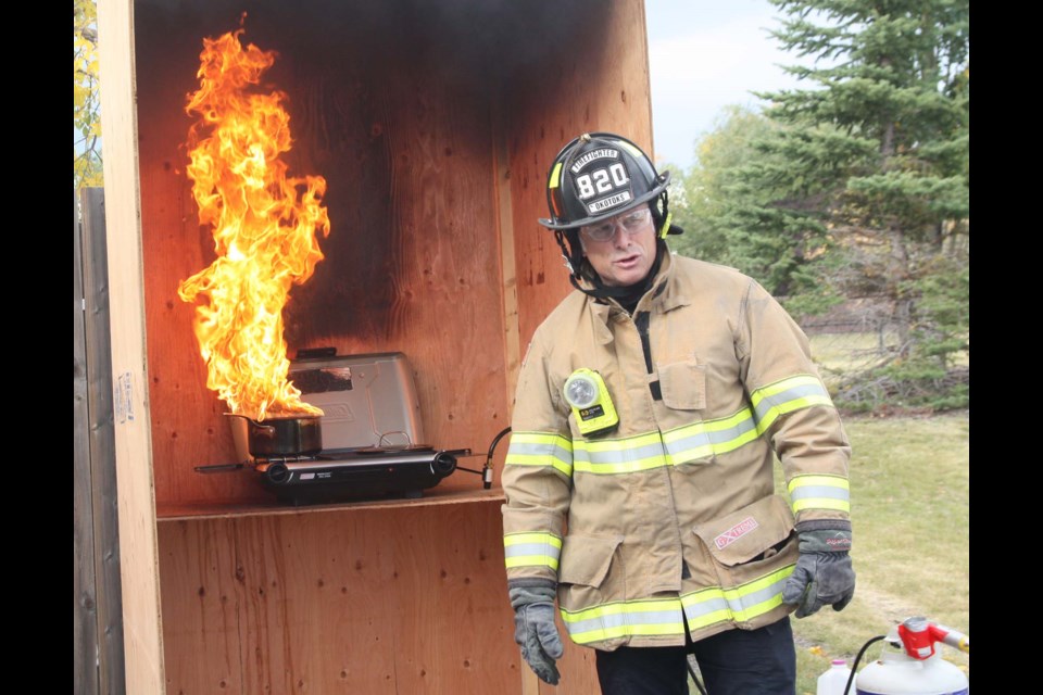 Okotoks firefighter Bob Button starts a grease fire on purpose in the makeshift kitchen he built for demonstrations. (Bruce Campbell, Western Wheel) 