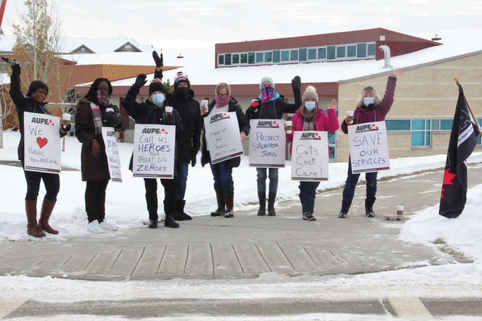Okotoks home-care workers stand outside the Okotoks Health and Wellness Centre, at Southridge Drive and Cimarron Boulevard, on Oct. 26 as part of a province-wide walk-out in protest of Alberta Health Services cuts. (Krista Conrad/Western Wheel)